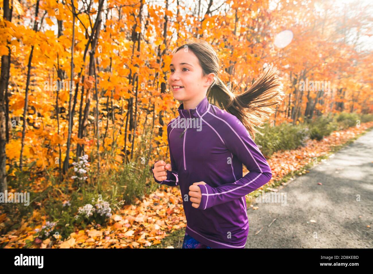 La ragazza sana di stile di vita che corre nel parco nella stagione autunnale Foto Stock