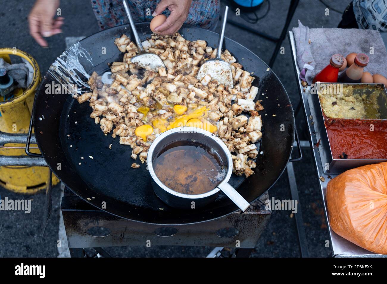 Falco malese cucina frittura torta di carote di ravanello con uovo dentro wok Foto Stock