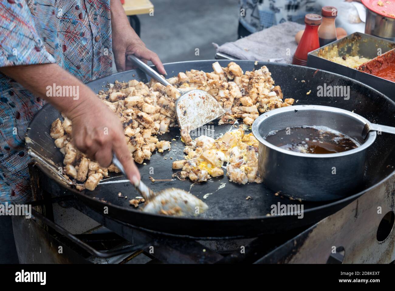 Falco malese cucina frittura torta di carote di ravanello con uovo dentro wok Foto Stock