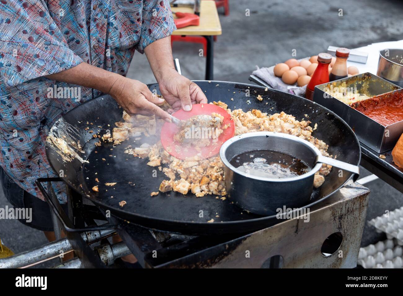Falco malese cucina frittura torta di carote di ravanello con uovo dentro wok Foto Stock