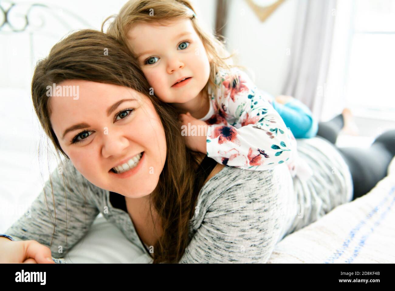 Una madre e figlia godere nel letto di casa Foto Stock