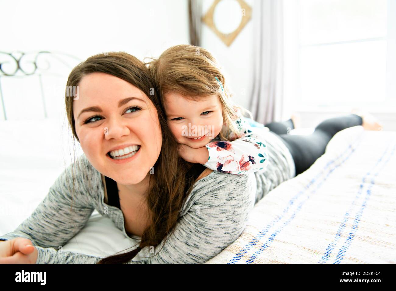 Una madre e figlia godere nel letto di casa Foto Stock