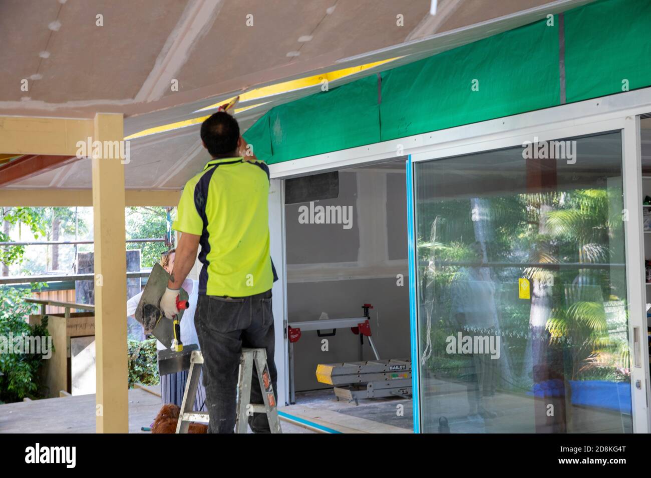 Lavori di ristrutturazione e ampliamento della casa di Sydney come commerciante che completa l'installazione di cartongesso, Sydney, NSW, Australia Foto Stock