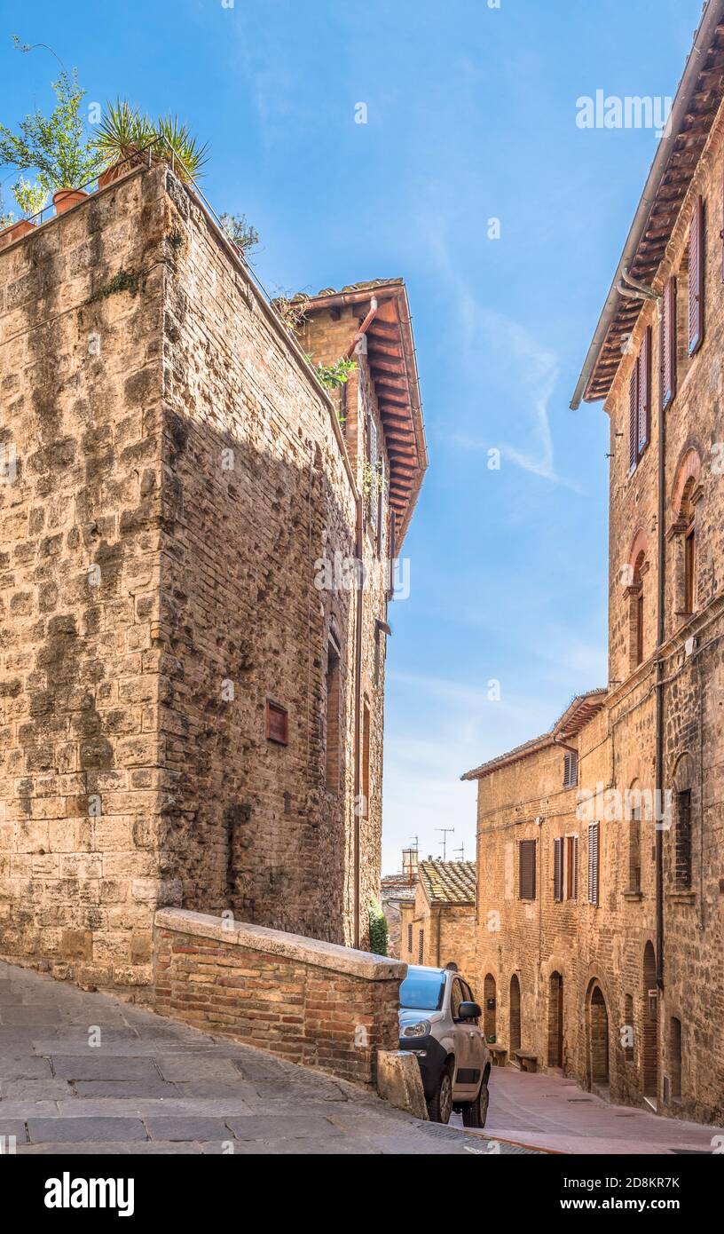 Strada stretta Via Palestro con auto nella città italiana Di San Gimignano Foto Stock