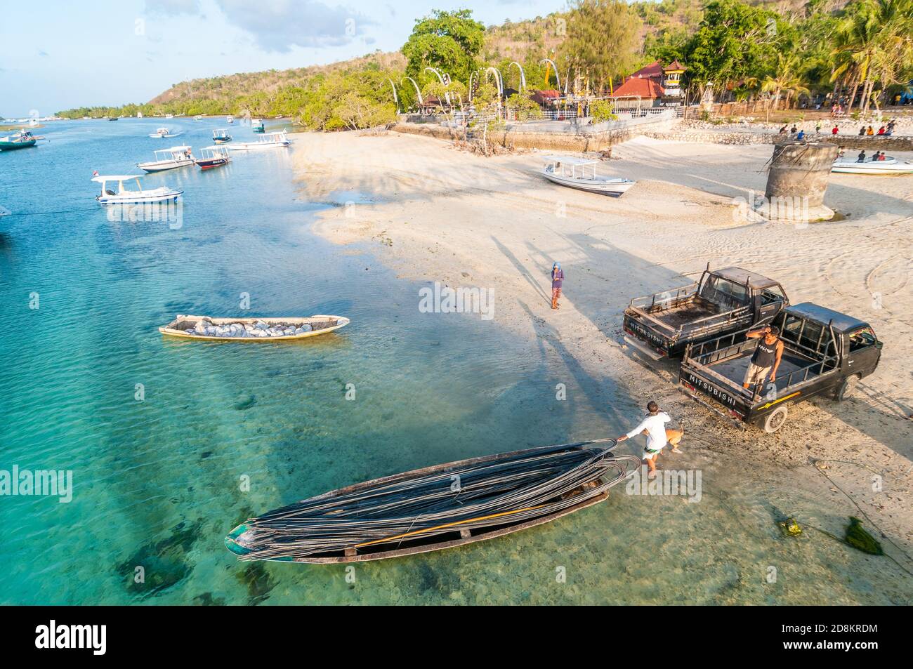 I lavoratori manuali scaricano aste di acciaio da una barca, Lembongan, Bali, Indonesia Foto Stock