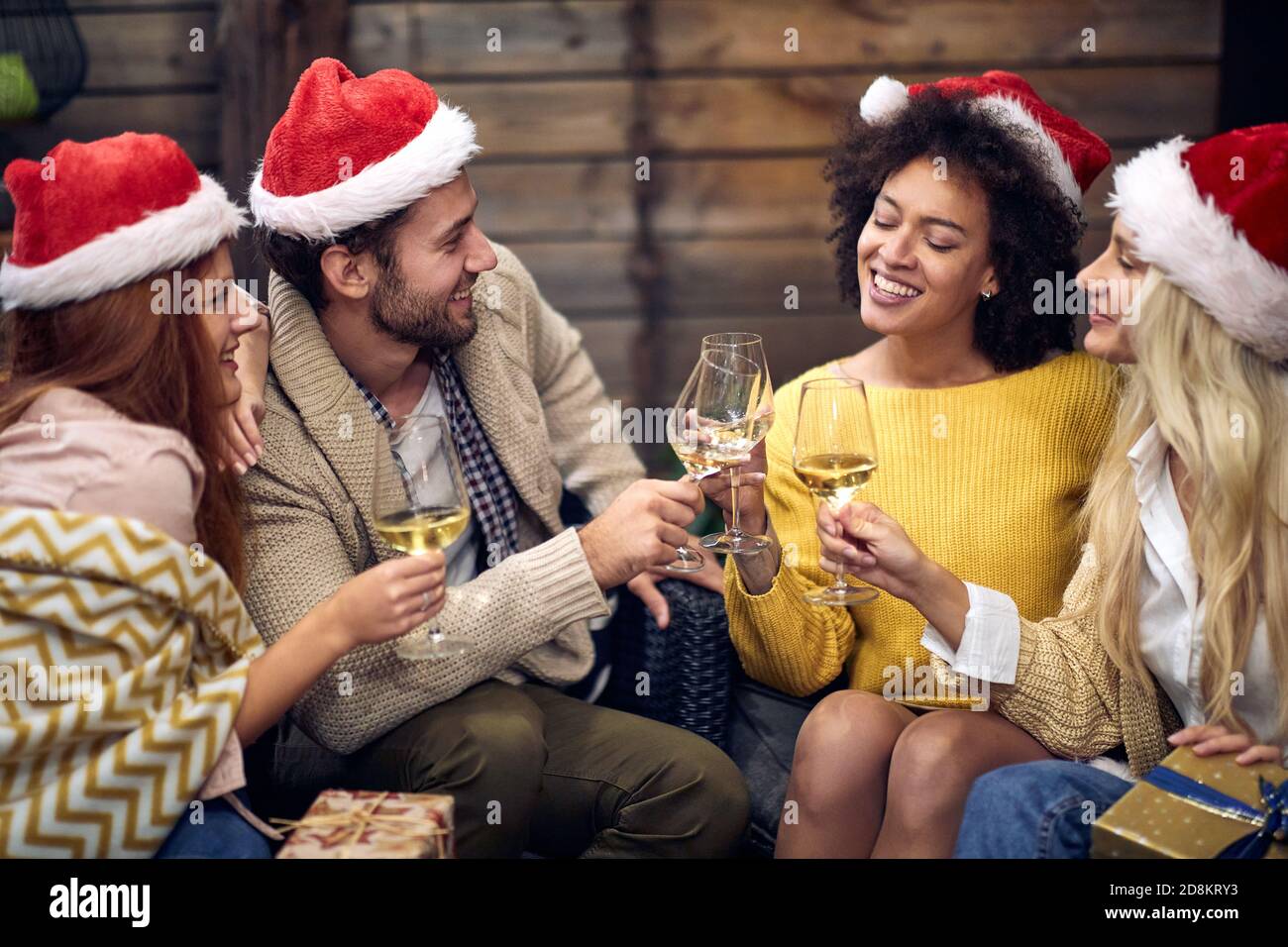 Gruppo di giovani felici che festeggiano il natale o il nuovo anno in un'atmosfera rilassata insieme. Natale, amici, toast, divertimento, concetto di festa Foto Stock