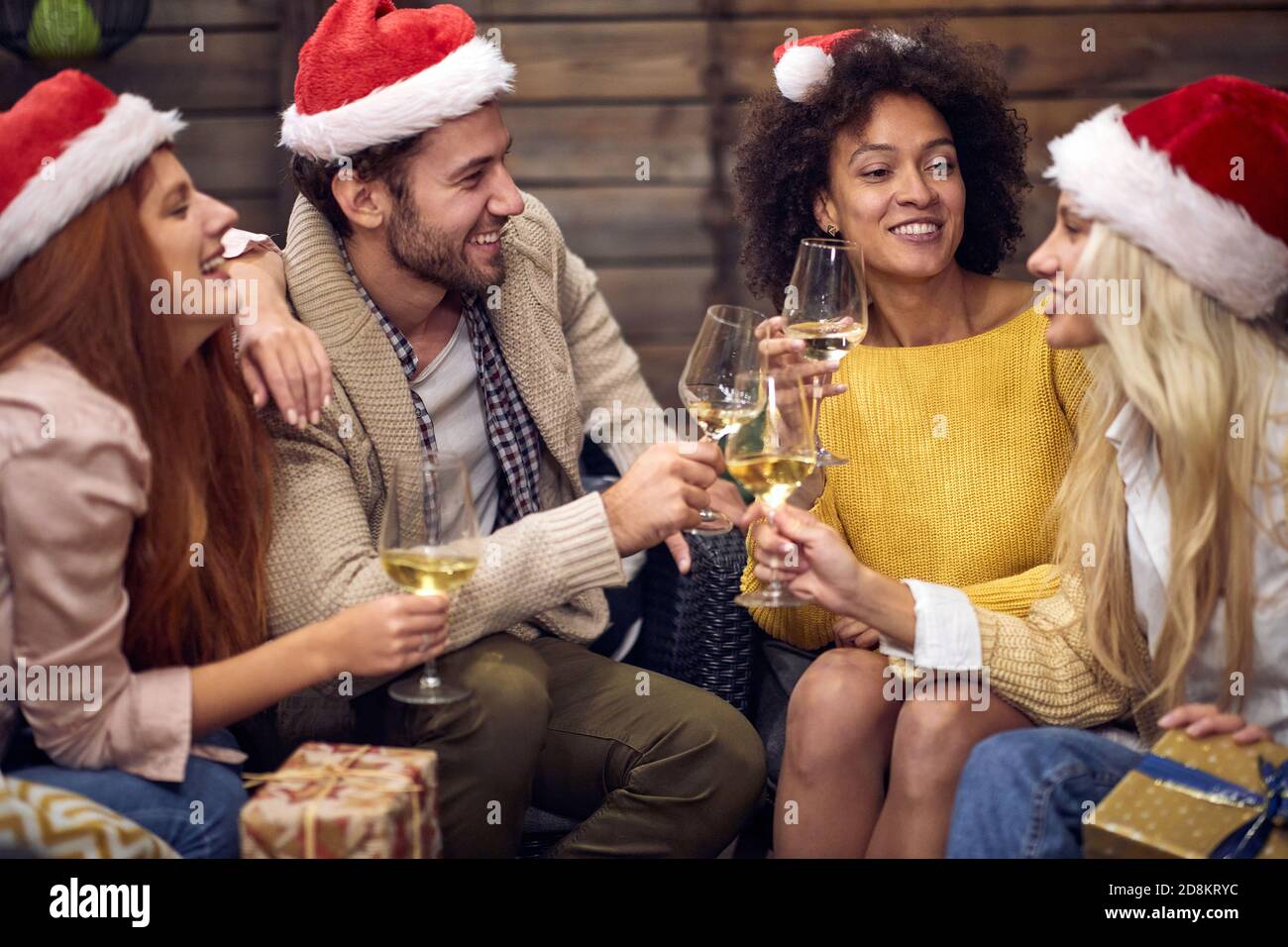 Gruppo di persone allegre che brinda a natale o festa di Capodanno in un'atmosfera rilassata insieme. Natale, amici, toast, divertimento, concetto di festa Foto Stock