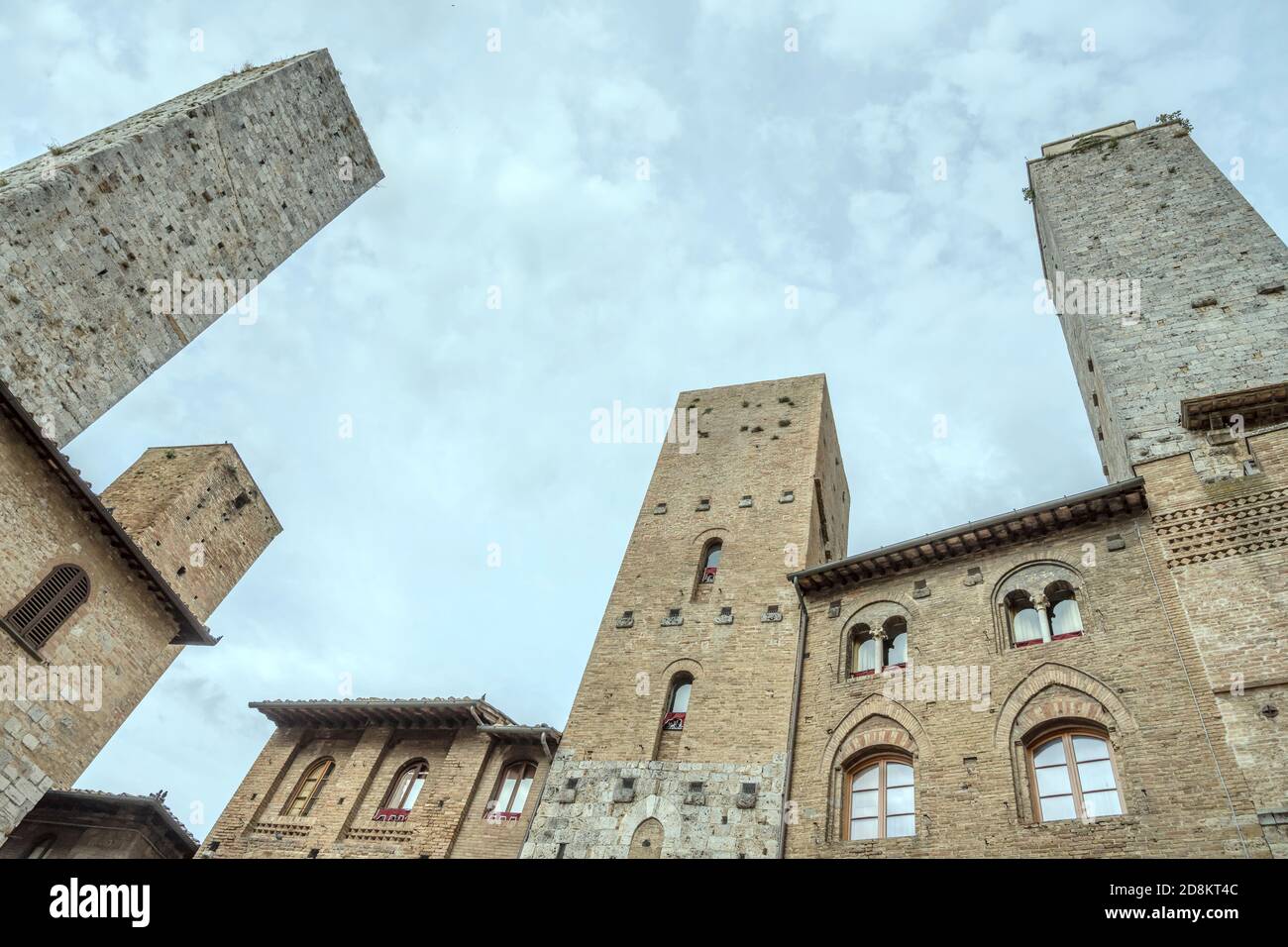 Paesaggio urbano con alte torri medievali che si estendono verso il cielo, sparate in luce a San Gimignano, Siena, Toscana, Italia Foto Stock