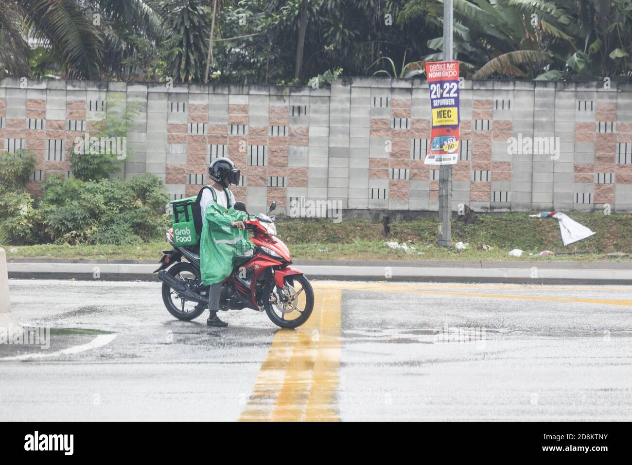 KUALA LUMPUR, MALESIA, 17 settembre 2019: Grabfood ordinato online in moto da pilota di grab, durante le giornate piovose. Grabfood è un Foto Stock