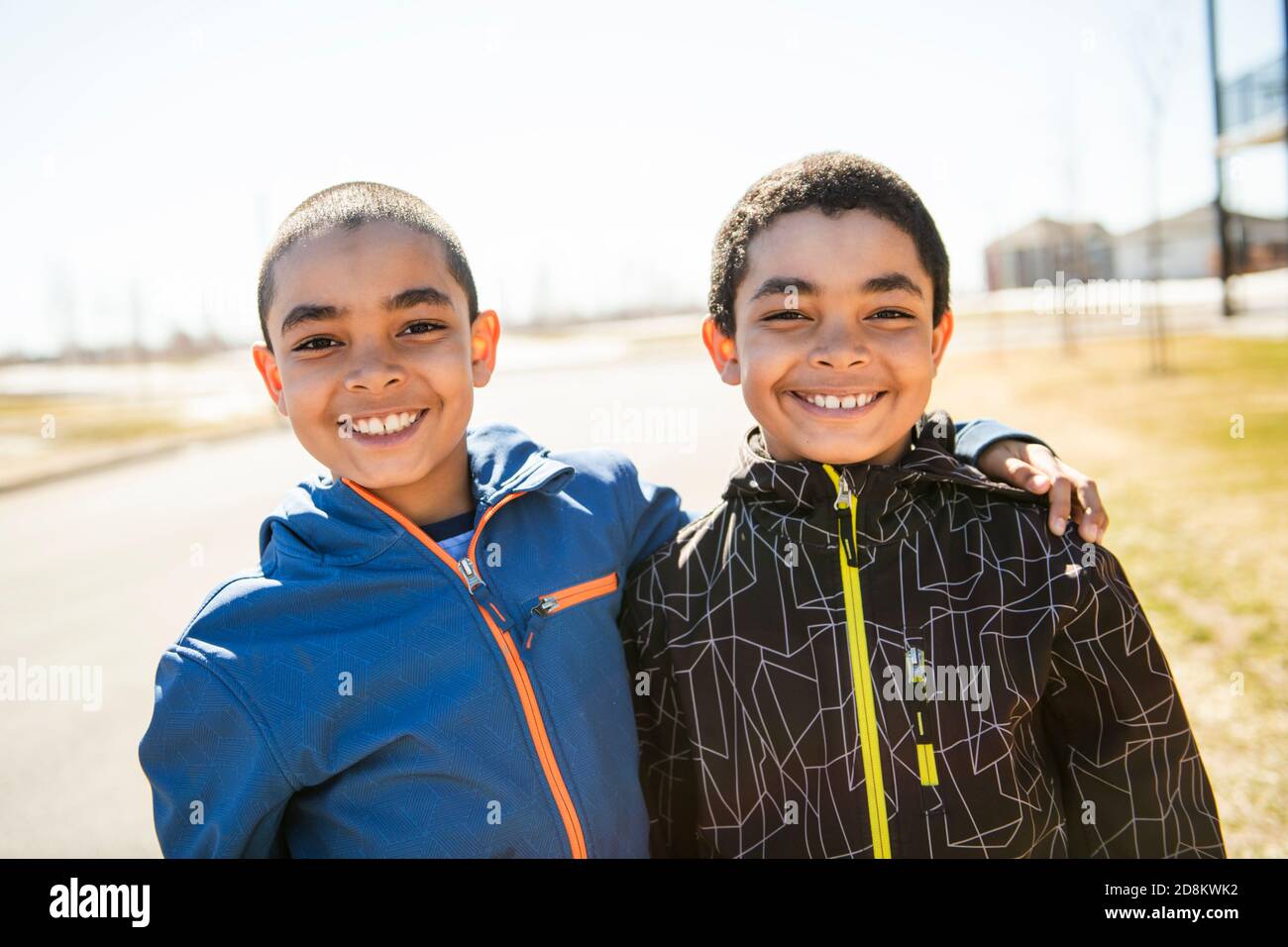 I bambini sorridono all'aperto in primavera con cappotto Foto Stock