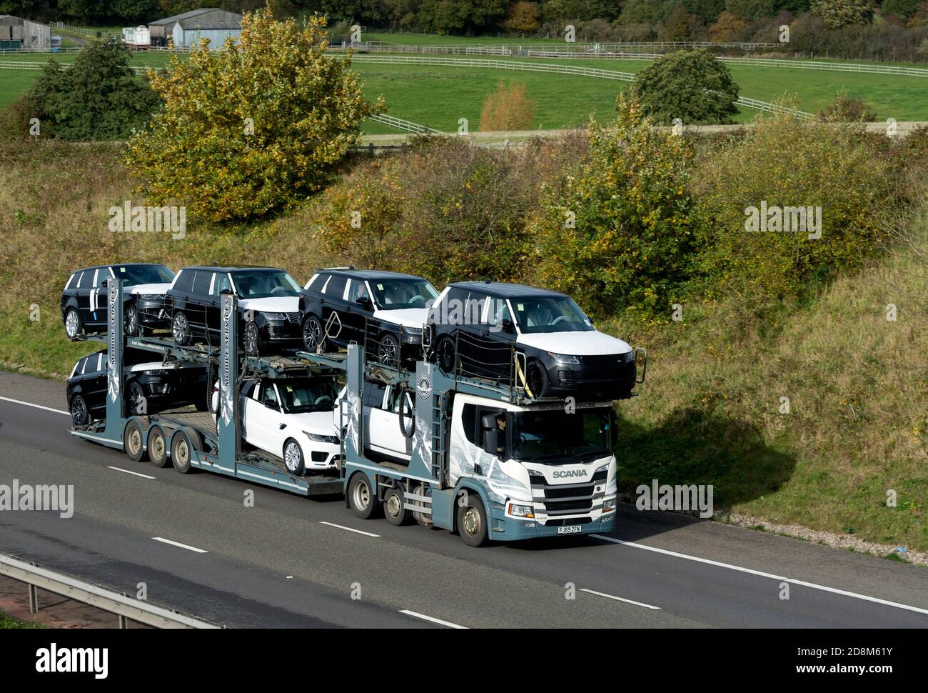 Servizi mobili Scania Transporter autocarro che trasporta nuove auto Land Rover sull'autostrada M40, Warwickshire, Regno Unito Foto Stock