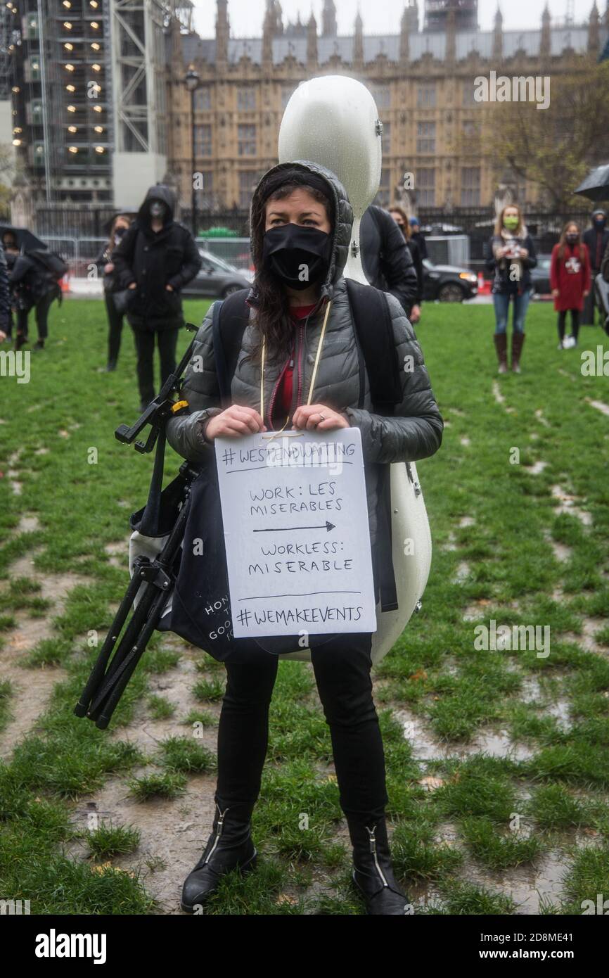 Londra UK 31 ottobre 2020 gli attori e i cantanti del West End si sono riuniti nella pioggia battente, da Parliament Square per cantare canzoni di Phantom of the Opera e Les Miserables, come un modo per attirare l'attenzione del governo britannico sulla loro situazione difficile e la mancanza di lavoro durante la pandemia, Con il governo che rifiuta di permettere ai teatri di aprire al pubblico Paul Quezada-Neiman/Alamy Live News Foto Stock