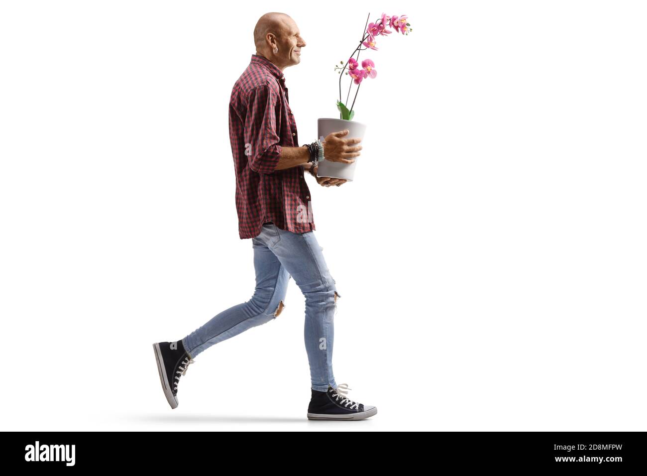 Foto di un uomo hipster che cammina e di un profilo a lunghezza intera portando un vaso di fiori orchidee isolato su sfondo bianco Foto Stock
