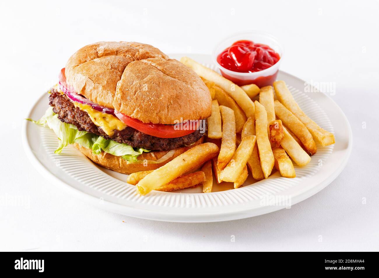 Cheeseburger in stile americano extra large con patatine fritte e ketchup su una superficie bianca Foto Stock