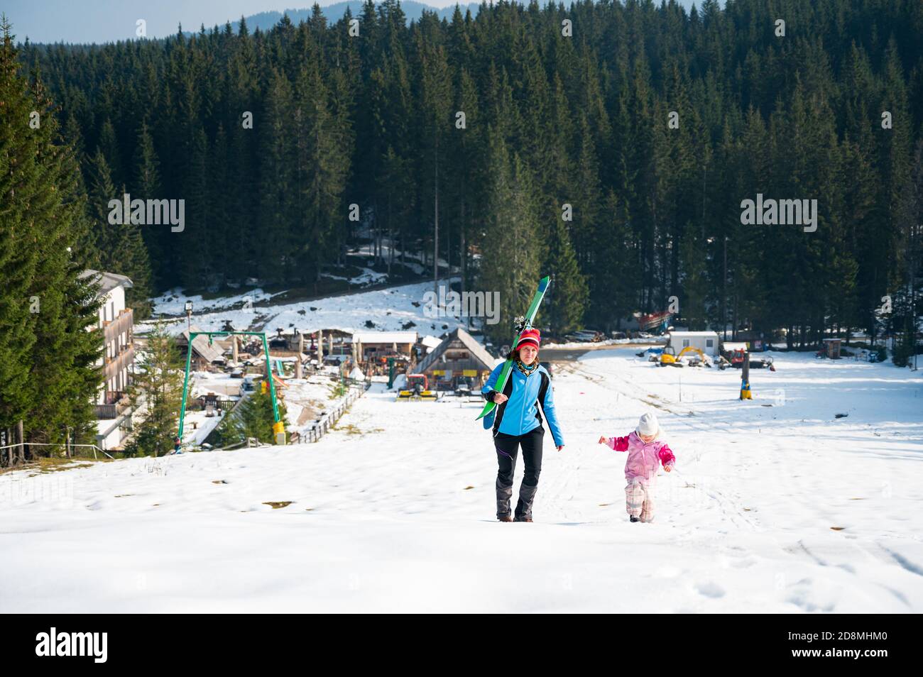 Madre e figlia che saliscono su una pista da sci. Foto Stock