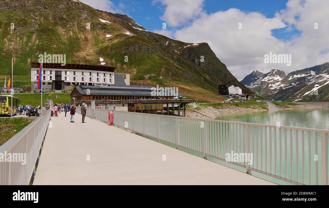 Silvretta Hochalpenstraße, Austria - 06/23/2019: Picco di strada alpina al bacino idrico di Silvretta con persone che camminano sulla diga, ristorante e hotel. Foto Stock