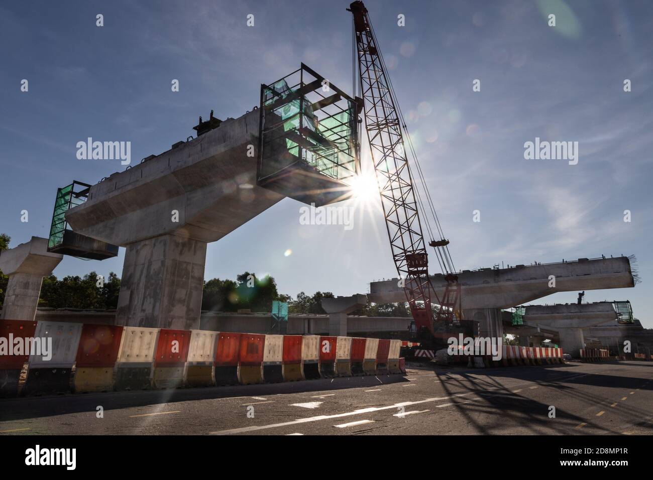 Silhouette con raggi del sole del mattino sull'infrastruttura del ponte del cavalcavia autostradale in costruzione Foto Stock