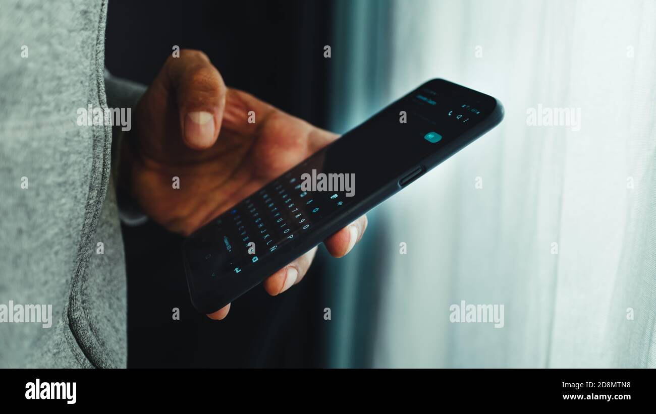 Un uomo che testava su un cellulare Foto Stock