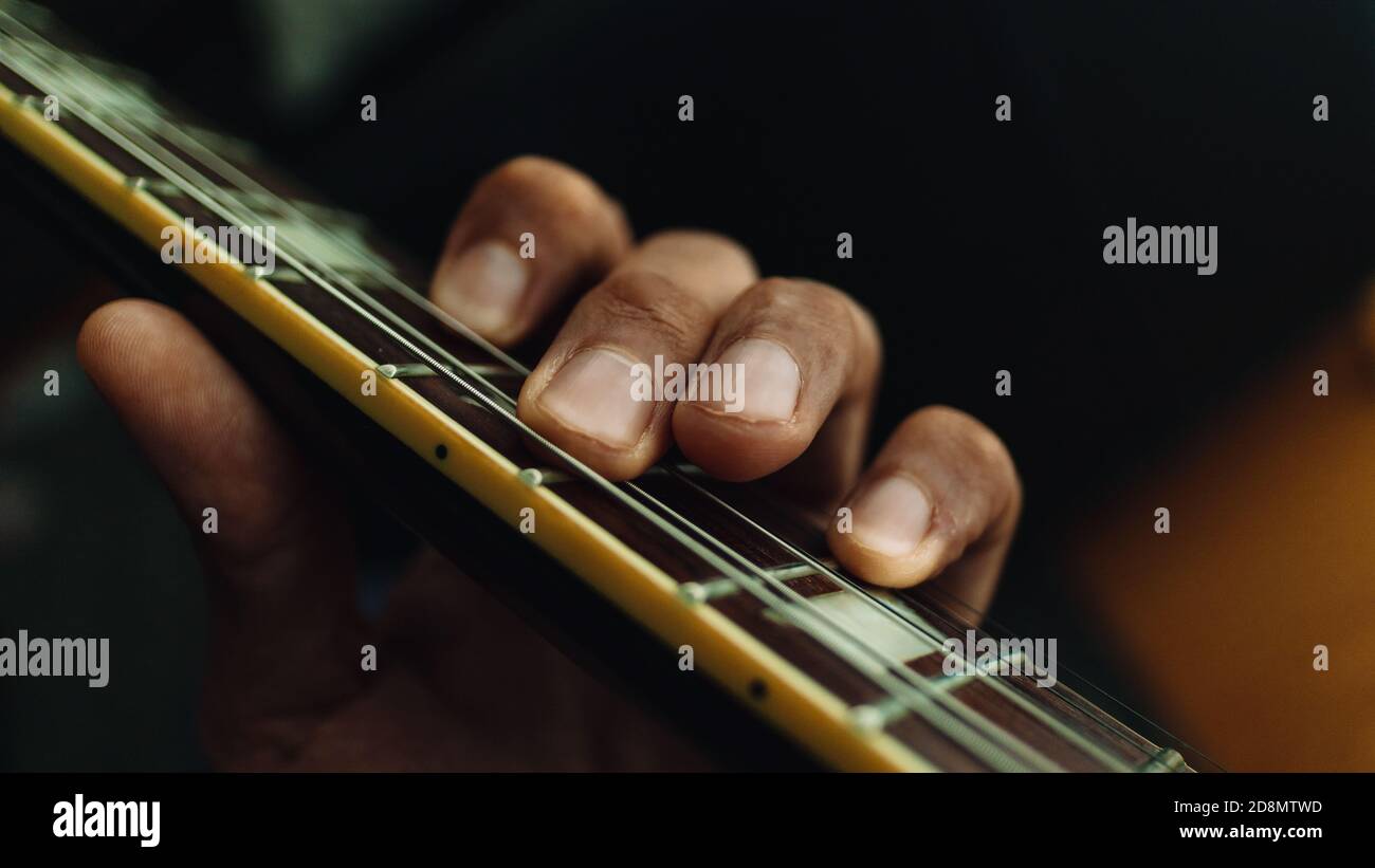 la mano sinistra suona la chitarra sulla tastiera Foto Stock