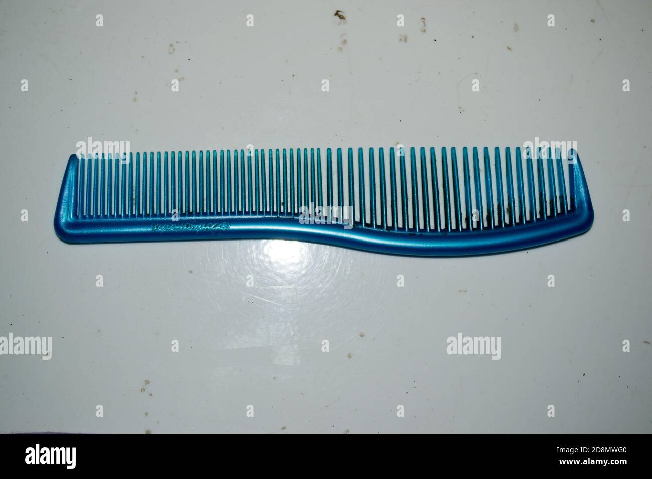 Un pettine/pettine per capelli in plastica di colore blu sporco, non lavato e disgustoso Foto Stock