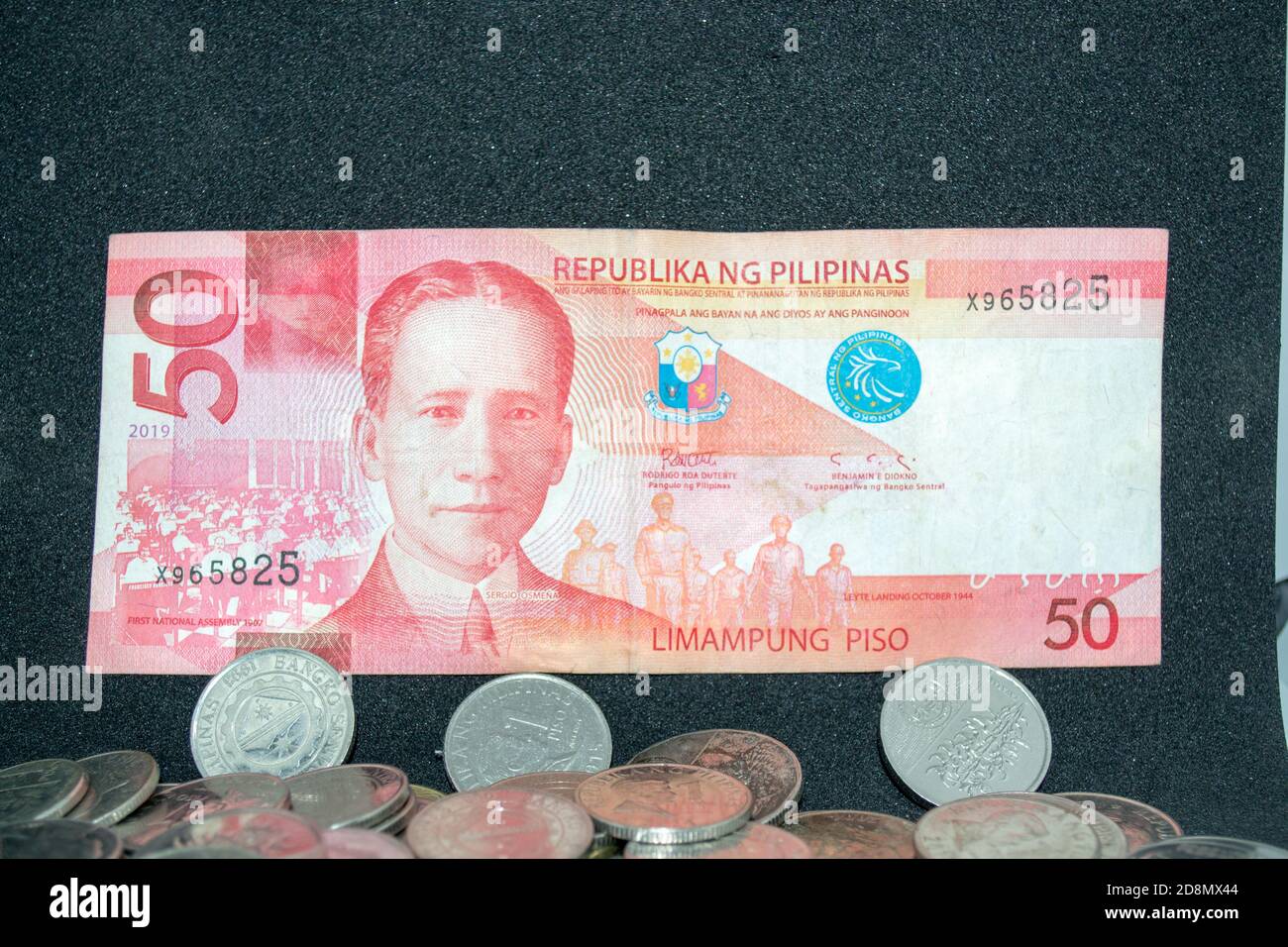 50 pesos filippini su carta fattura sopra una pila di peso monete Foto  stock - Alamy