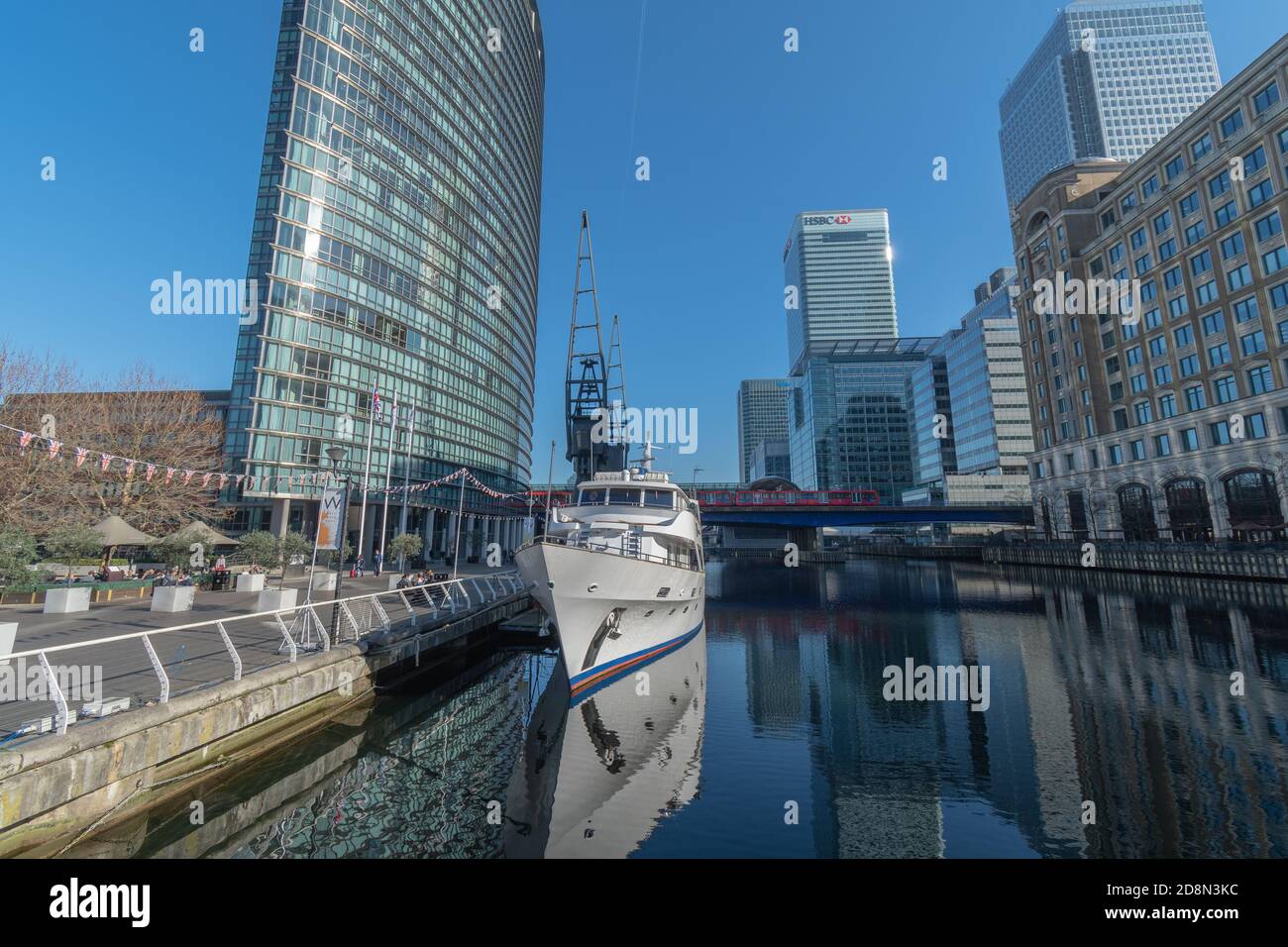 Una barca in primo piano, con West India Quay DLR e HSBC e Barclays HQ sullo sfondo Foto Stock