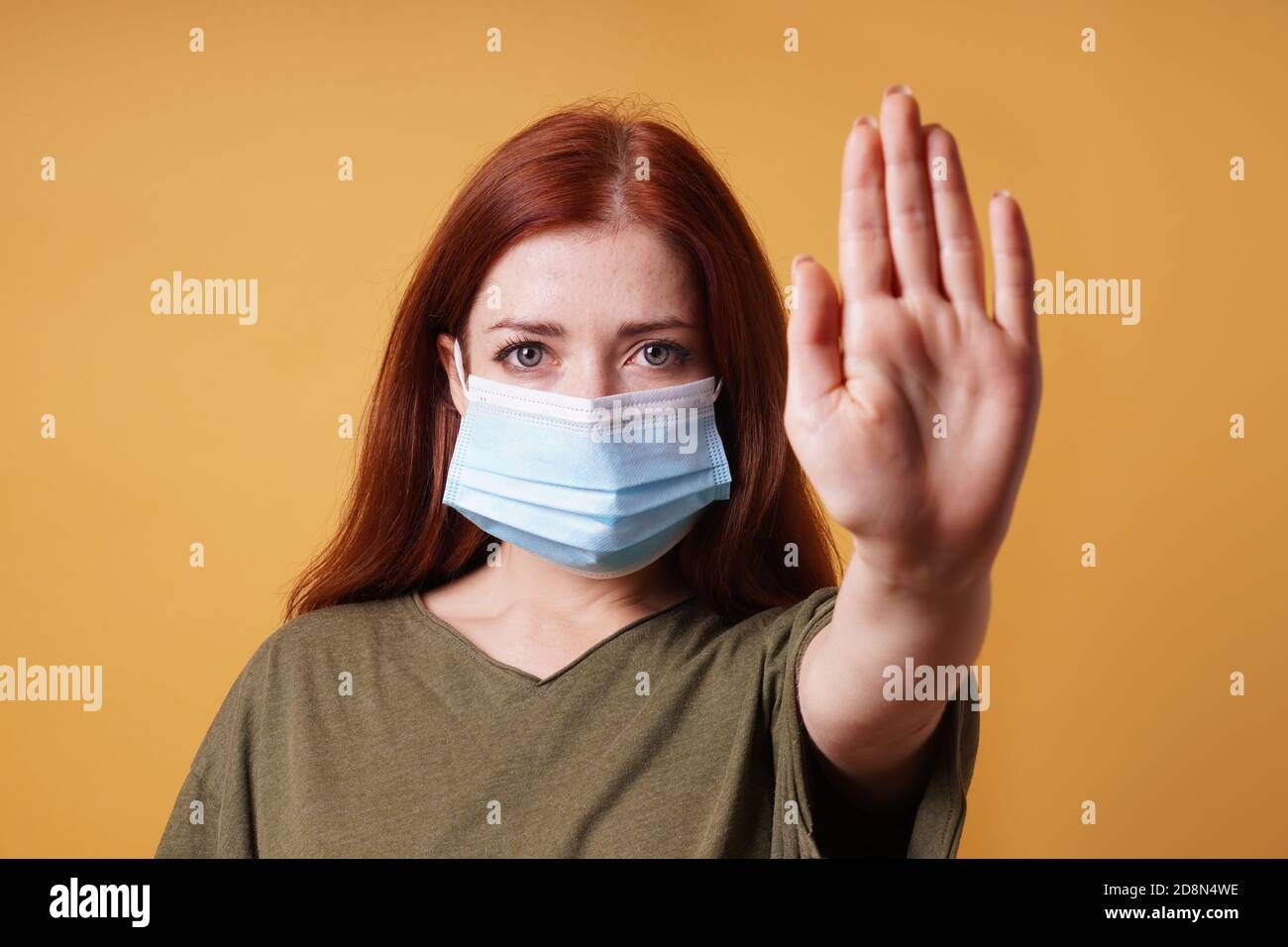 giovane donna che indossa maschera medica faccia facendo gesto di arresto con la sua mano - nessun ingresso senza maschera durante corona covid-19 concetto pandemico Foto Stock
