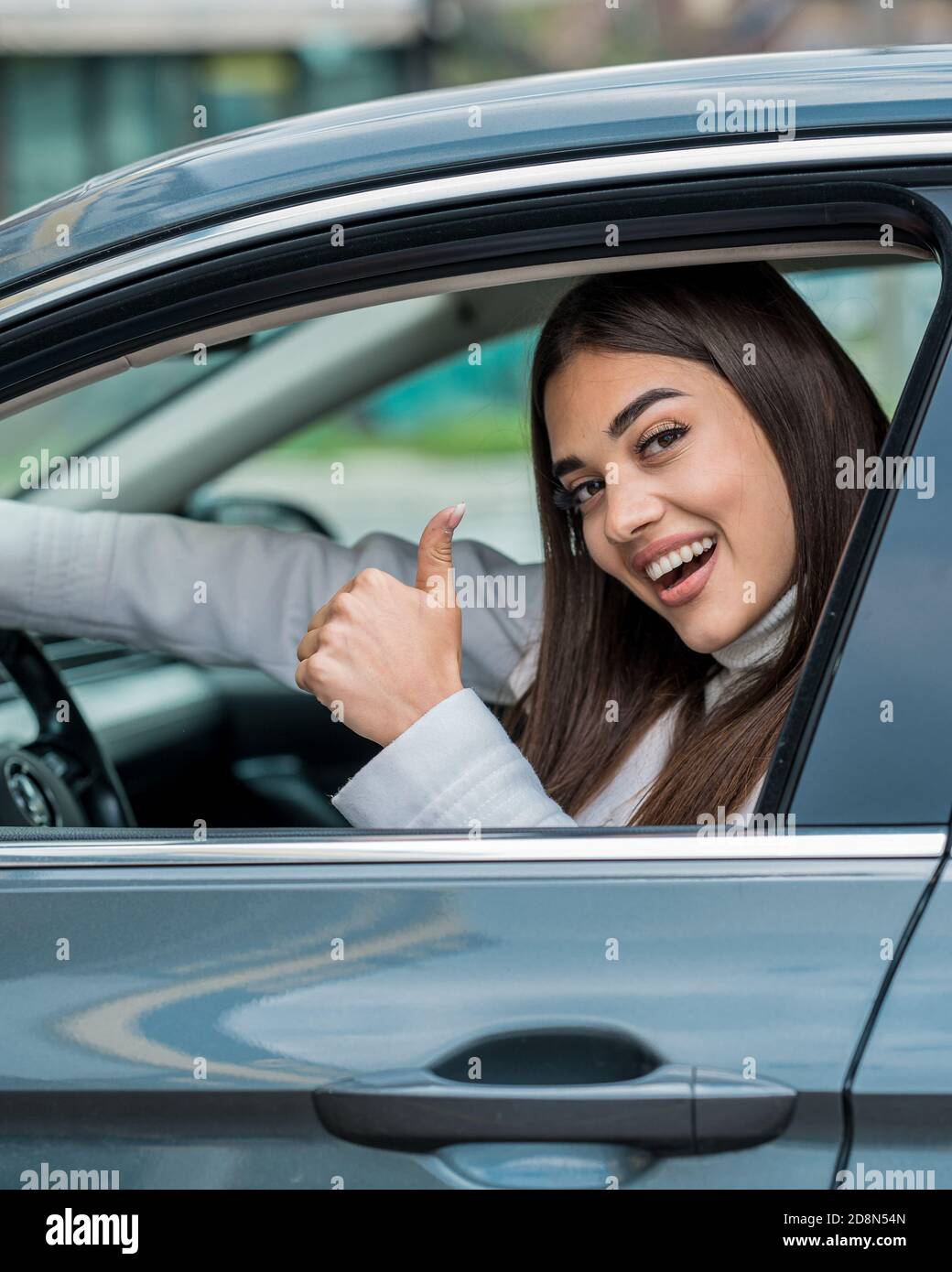 Bella donna in posa al volante della sua auto Foto Stock