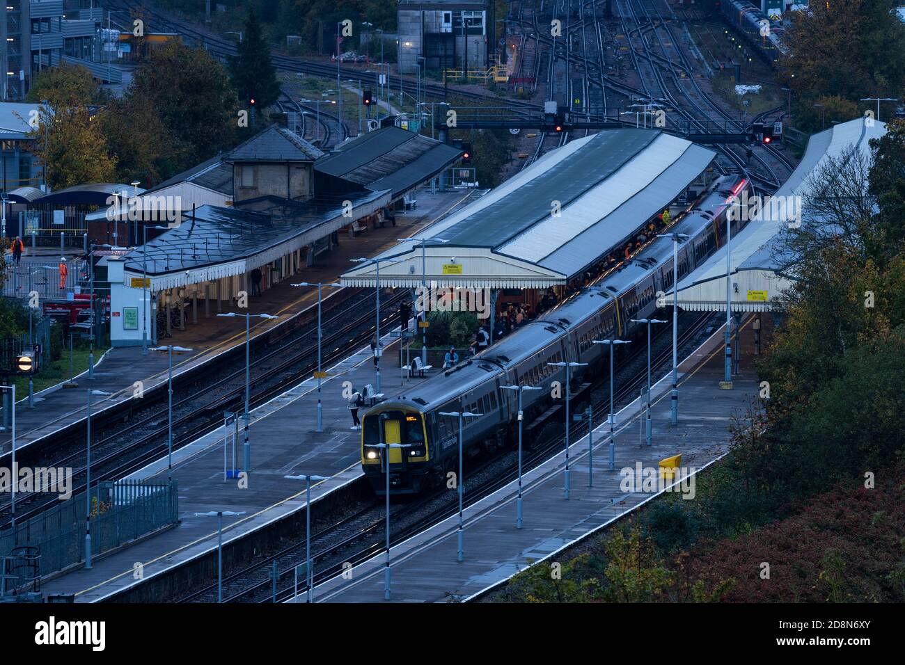 Pendolari a bordo di un treno South Western Railway al buio di una mattina presto alla stazione ferroviaria di Basingstoke, Hampshire, Regno Unito Foto Stock