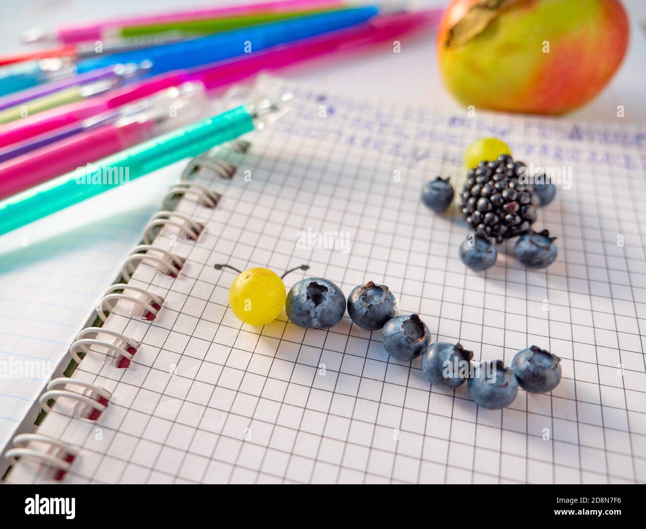 Bambini frutti di bosco sano mestiere. Fare e mangiare fresco. Semplice artigianato capretto: Mirtillo e uva caterpillar, mora e mirtillo uomo in un notebook Foto Stock