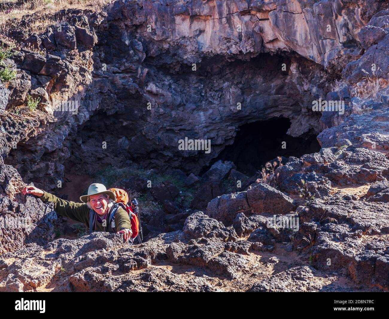 Il visitatore emerge da un tubo di lava, Lava Flow Trail, Snow Canyon state Park, Saint George, Utah. Foto Stock