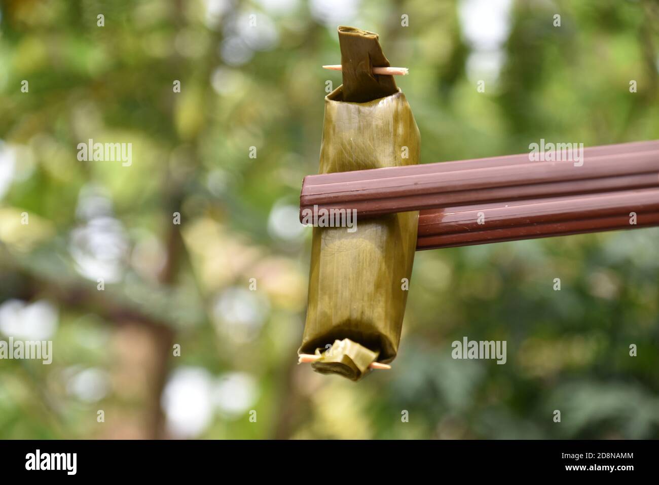 Il cibo indonesiano, cioè il Lemper, è riso glutinoso e pollo triturato avvolto in foglie di banana Foto Stock