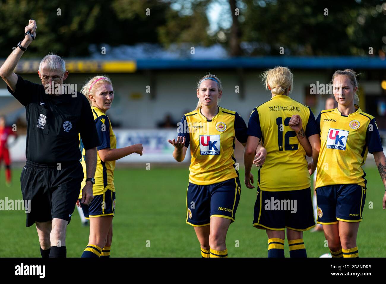 Un arbitro guida quattro calciatori femminili formando una parete a dieci metri da un calcio libero. Foto Stock Un arbitro guida quattro calciatori femminili formando una parete a dieci metri da un calcio libero. Foto Stock