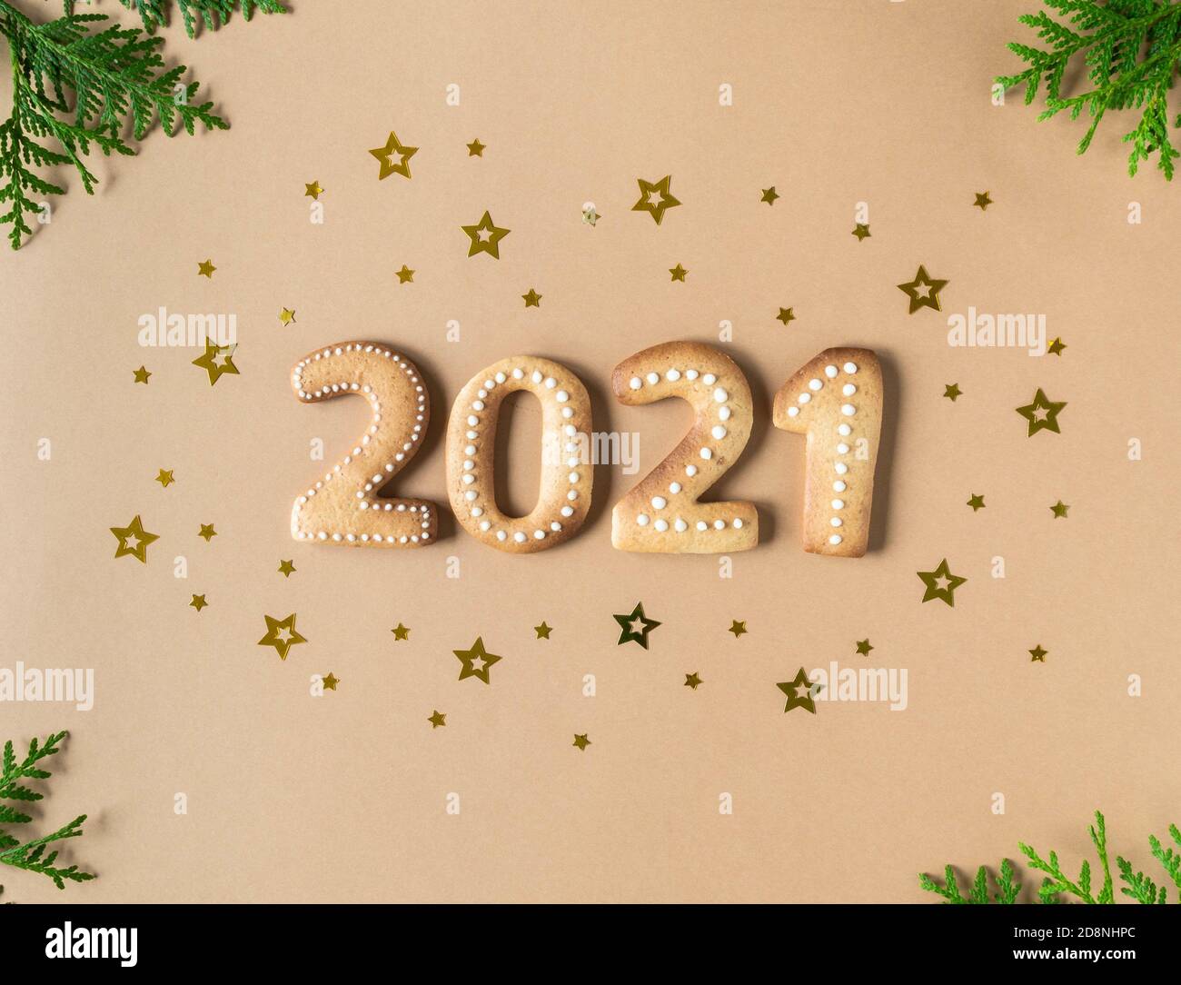 Biscotti di pan di zenzero sotto forma di numeri, pan di zenzero Capodanno 2021 su sfondo beige. Vista dall'alto. Decorazioni natalizie con stelle d'oro confetti. Foto Stock