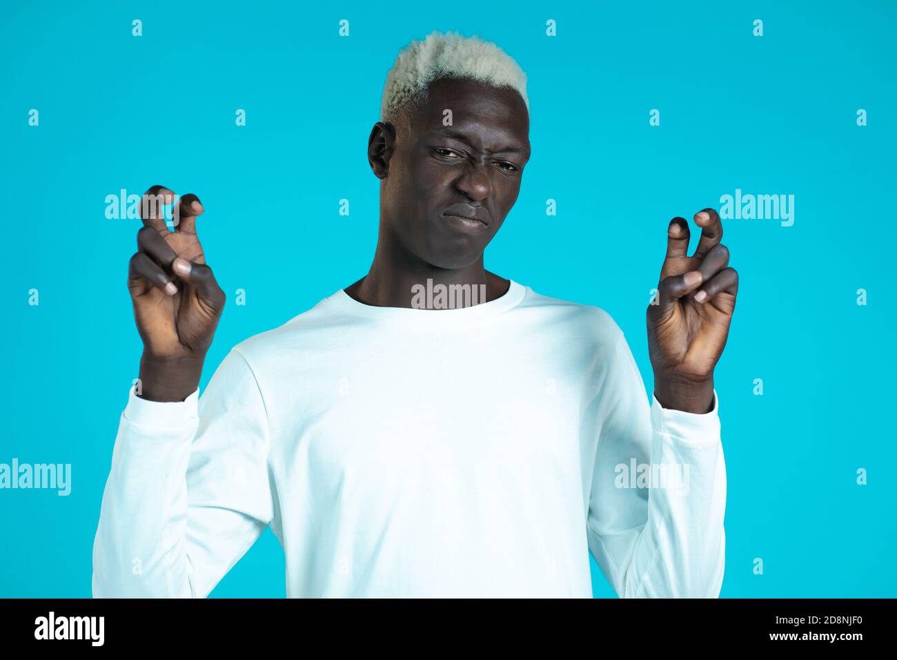 Uomo africano con capelli bianchi che mostra con le mani e due dita come virgolette gesto, piega le dita isolate su sfondo blu. Molto divertente, ironia Foto Stock