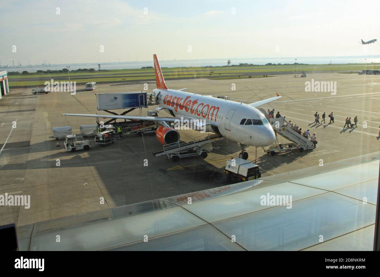 I passeggeri che si allontano scendendo da un facile aereo di linea aerea budget jet Sulla pista all'aeroporto di Manchester Inghilterra UK Foto Stock