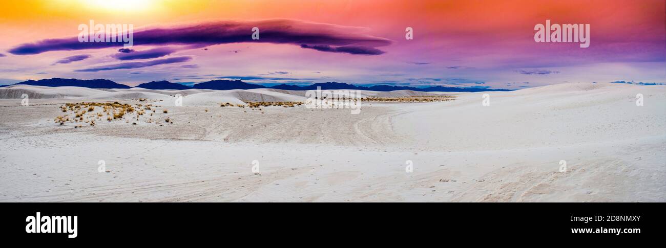 Dune di sabbia di gesso del White Sands National Park, New Mexico USA. Con colori vivaci all'orizzonte e montagne scure. Foto Stock