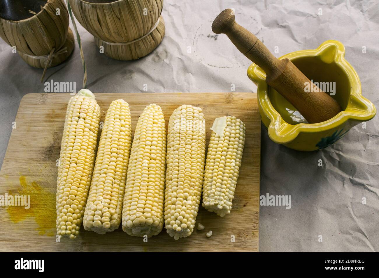 Girato dall'alto su alcuni corncobs grezzi e un valenciano malta ceramica Foto Stock