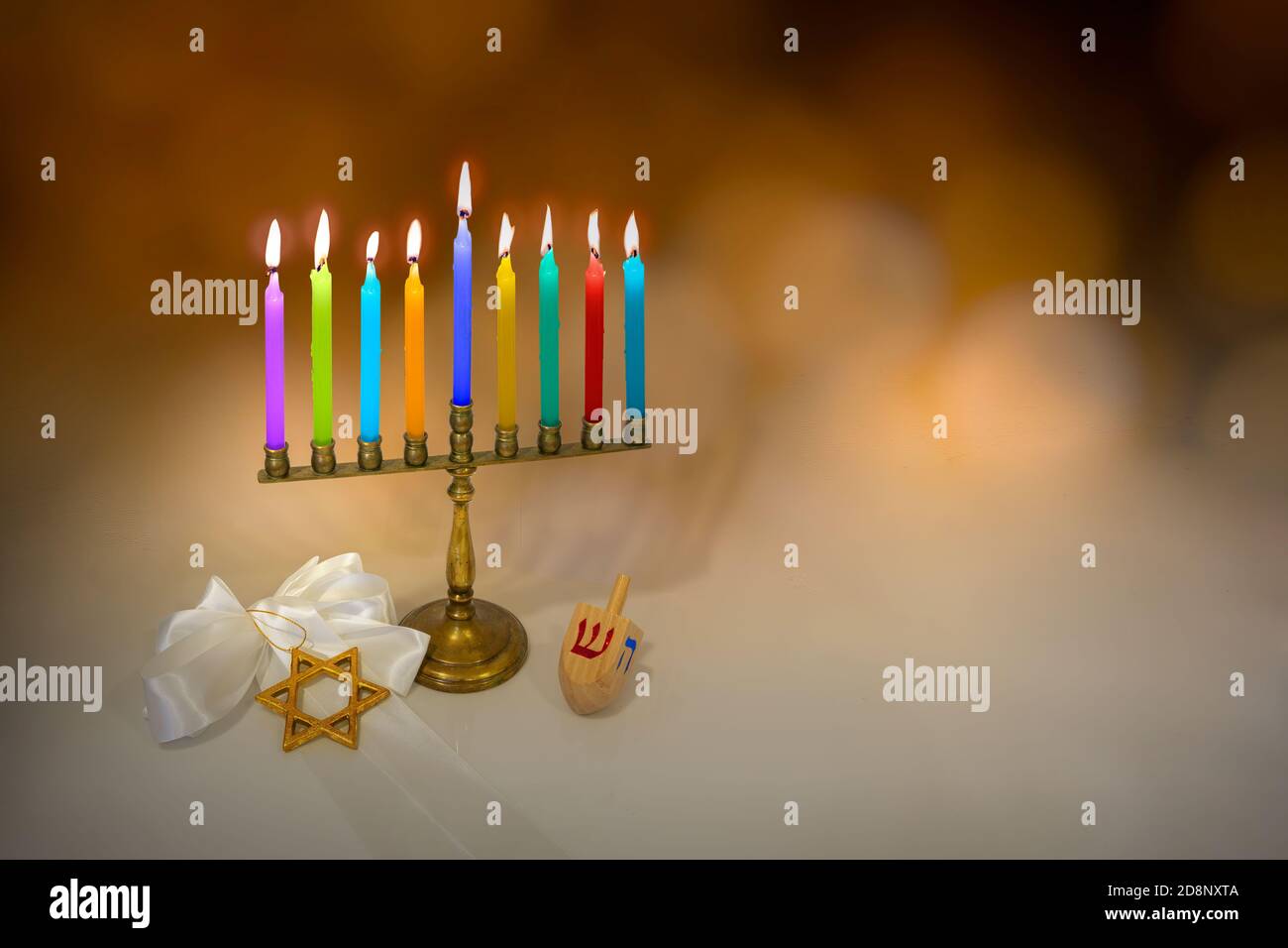 Festa ebraica Hanukkah sfondo con menorah (tradizionale candelabro), candele, Dreidel (girando in cima), e stella di David con sfondo sfocato. Foto Stock