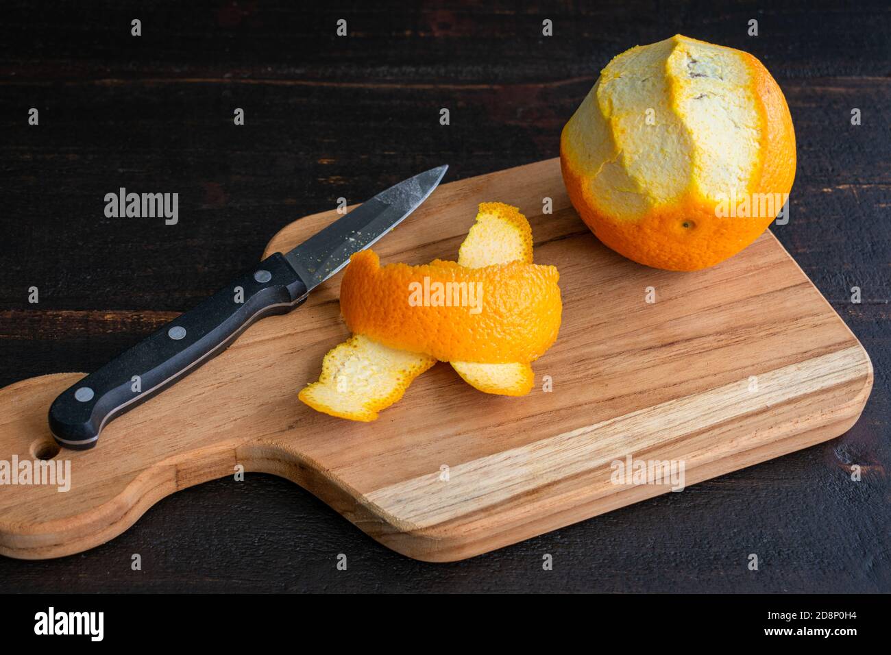 Spellatura delle strisce di Orange Zest: Spellatura di un arancio con un coltello di spellatura Foto Stock
