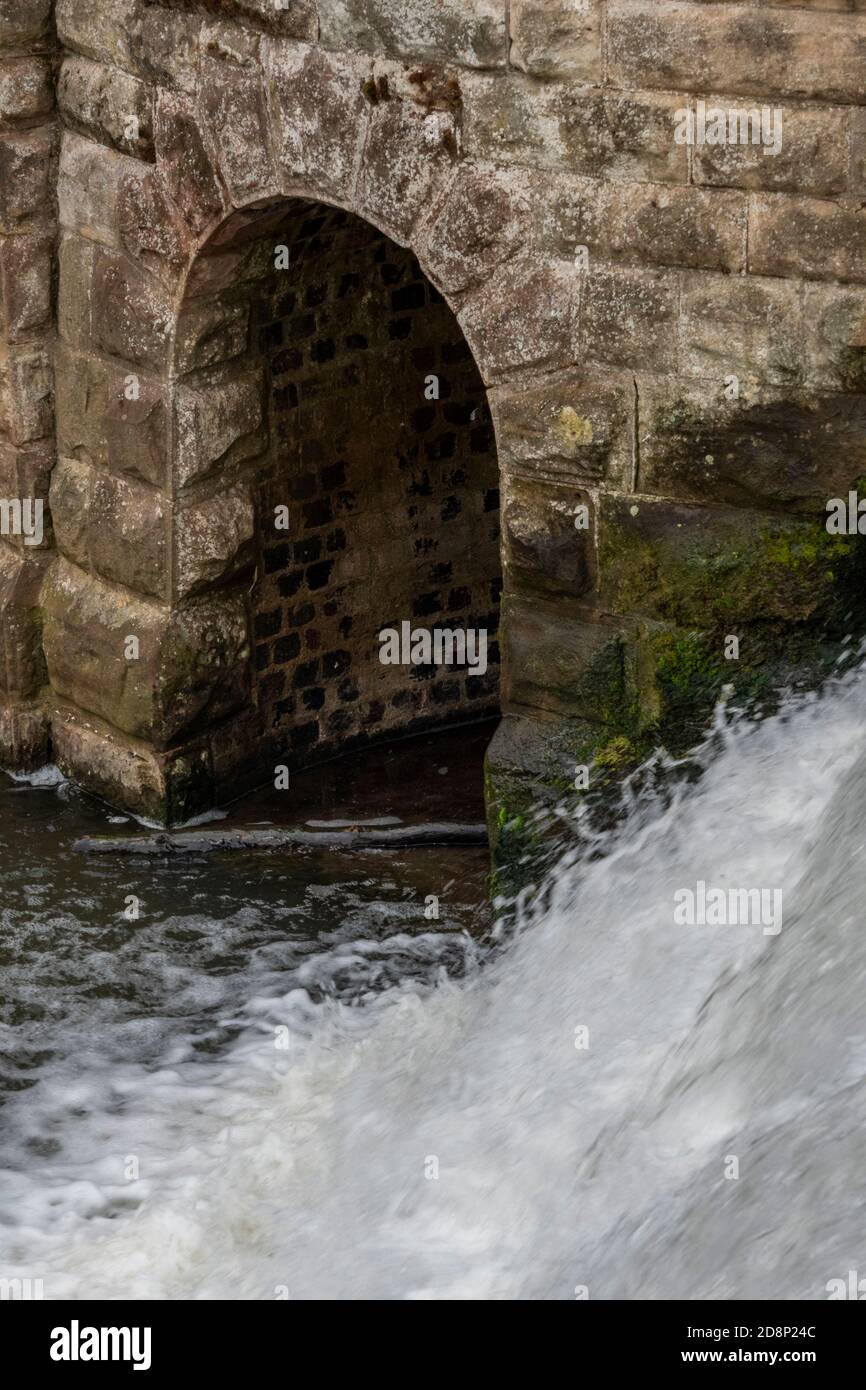 cascata o stramazzo acqua che cade su un ponte su un fiume nella spa reale di leamington. acqua che scorre su caduta o stramazzo. Foto Stock