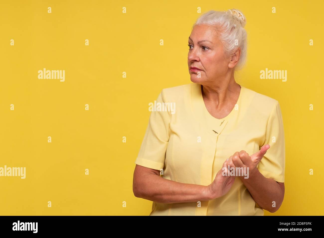 Donna ispanica anziana seria che guarda da parte sul copyspace Foto Stock