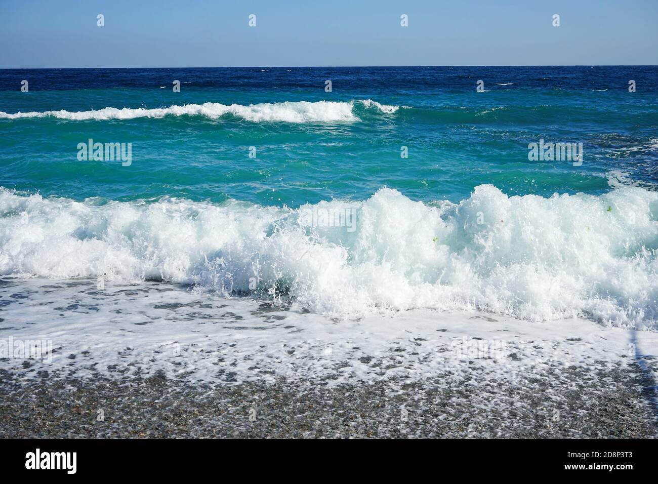 belle onde blu con schiuma bianca sulla spiaggia Foto Stock