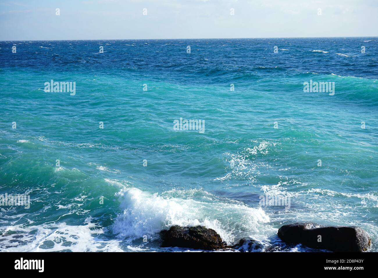 belle onde blu con schiuma bianca sulla spiaggia Foto Stock