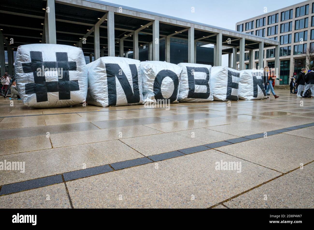 ' NOBER' viene scritto come attivisti climatici in costumi di pinguino protestano per l'apertura del nuovo aeroporto internazionale di Berlino Brandeburgo (BER). Foto Stock