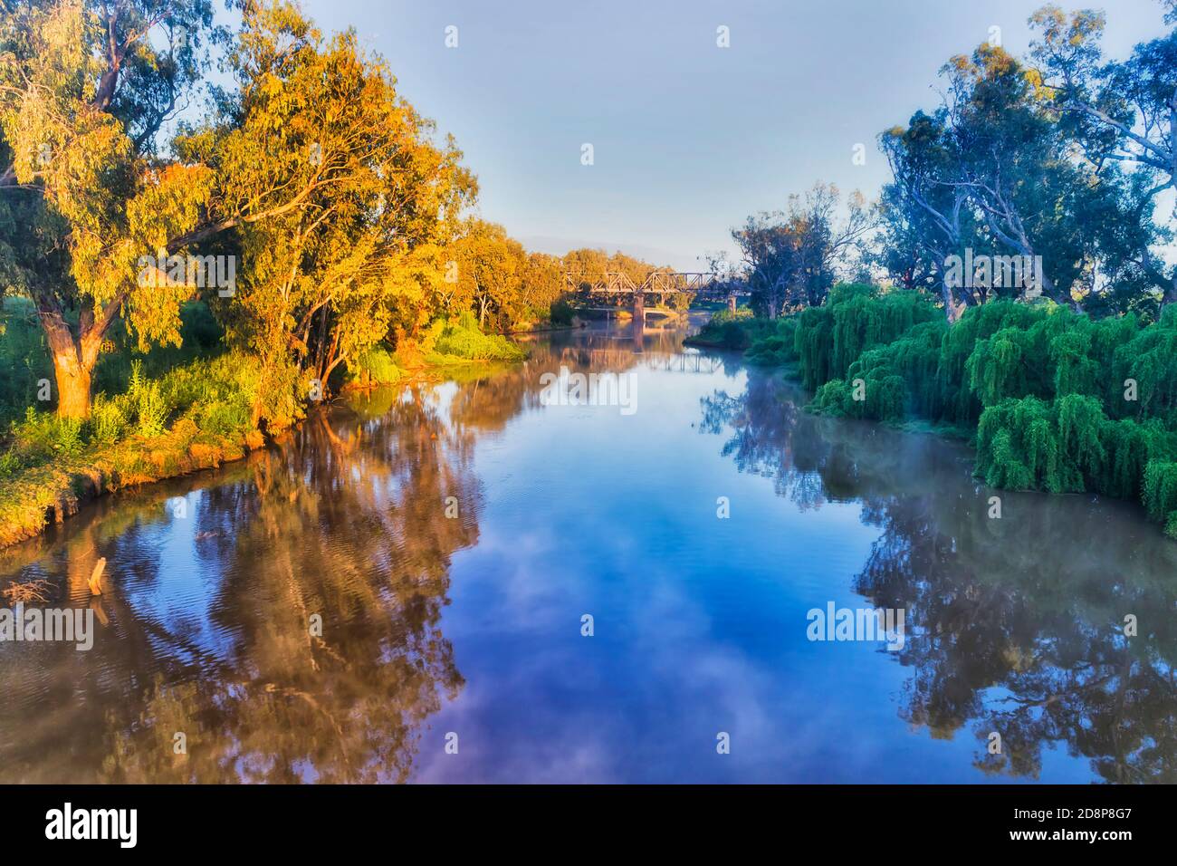 Ancora calma fiume Macquarie all'alba vicino a ponte ferroviario storico nella città di Dubbo delle pianure occidentali grandi dell'Australia. Foto Stock