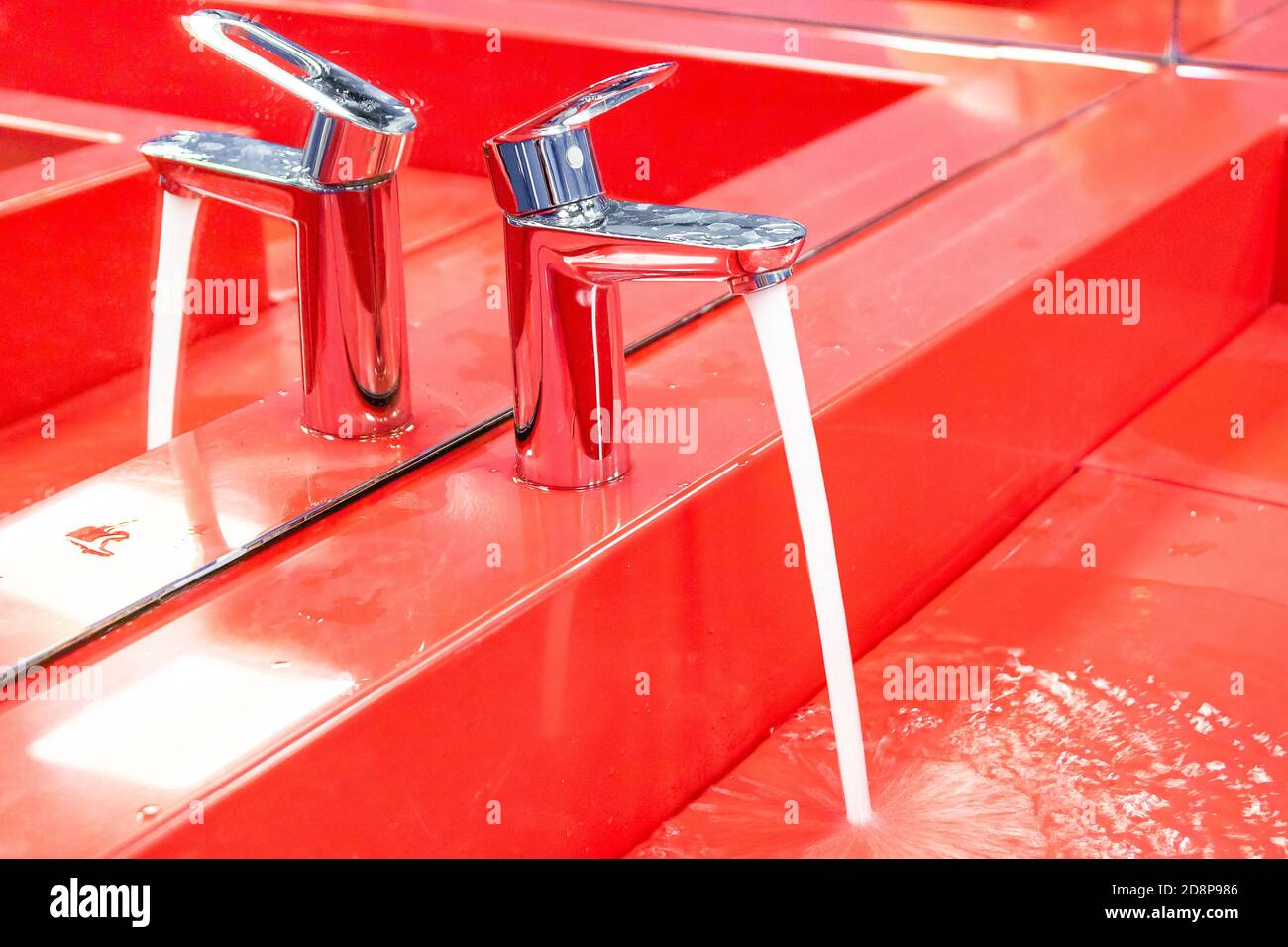 l'acqua scorre dal rubinetto al lavandino Foto Stock