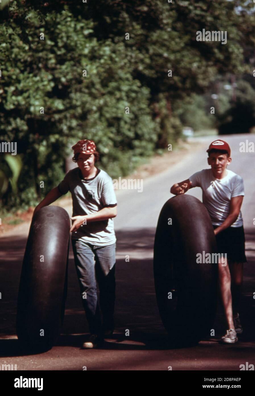 Due giovani con camion tubi interni dirigono verso il fiume Chattahoochee lungo via escowee in Helen. Il tubing lungo il fiume è un passatempo preferito durante l'estate. Helen era una tipica piccola comunità montana di circa 270 persone, 90 miglia a nord-est di Atlanta fino al 1969. A quel tempo gli uomini d'affari e i residenti locali approvarono la ristrutturazione del quartiere degli affari con un tema alpino bavarese Foto Stock