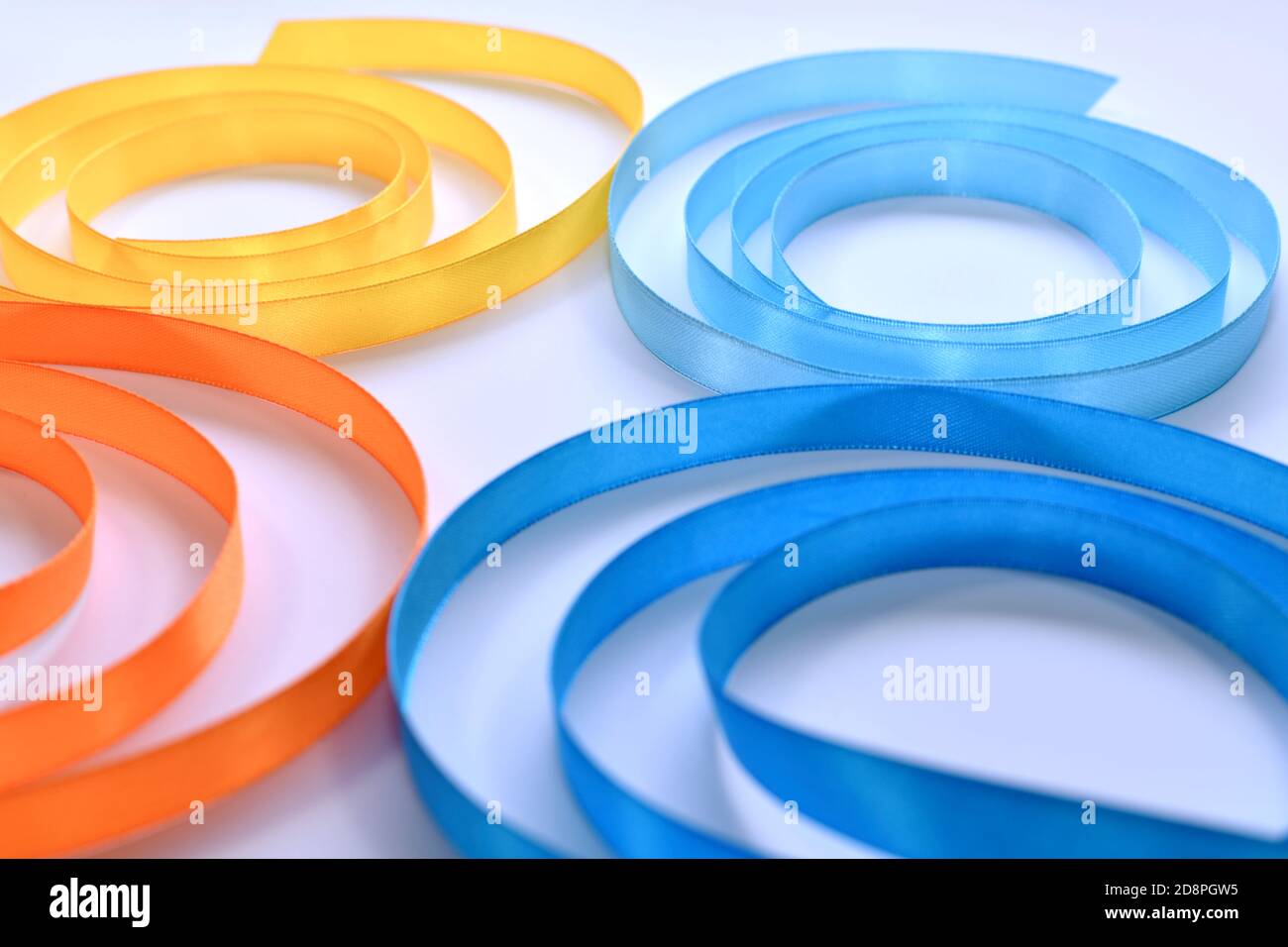 Frammento di una farfalla composta da nastri di raso ritorti a spirale. Quattro ali su uno sfondo chiaro. Foto Stock