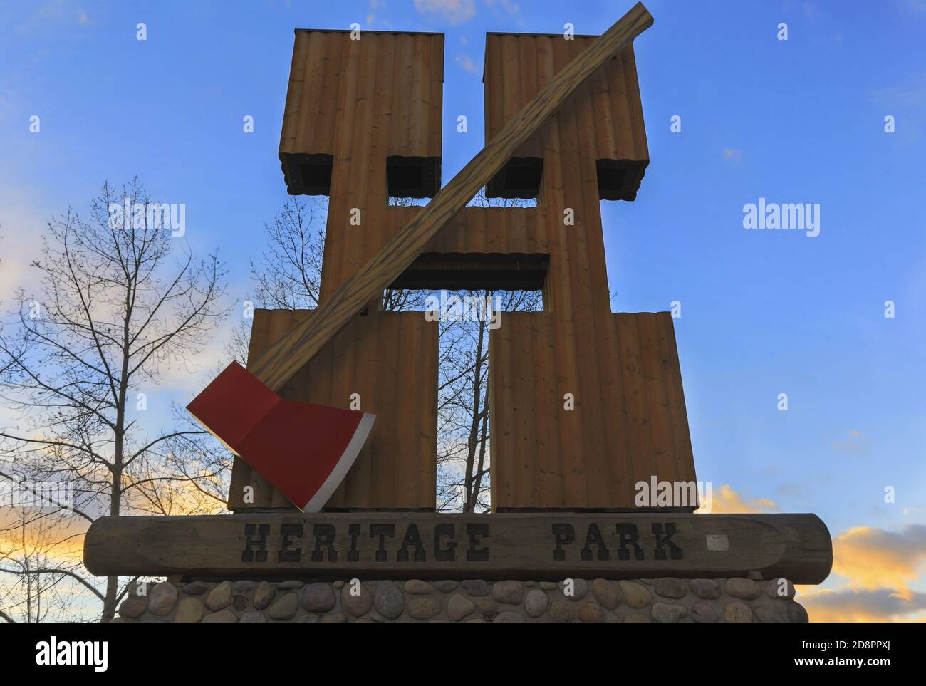 Heritage Park Sign di Glenmore Reservoir nel sud-ovest Calgary, Alberta costituito da grande lettera H e Woodcutter o Lumberjack Axe su una parete di pietra Foto Stock